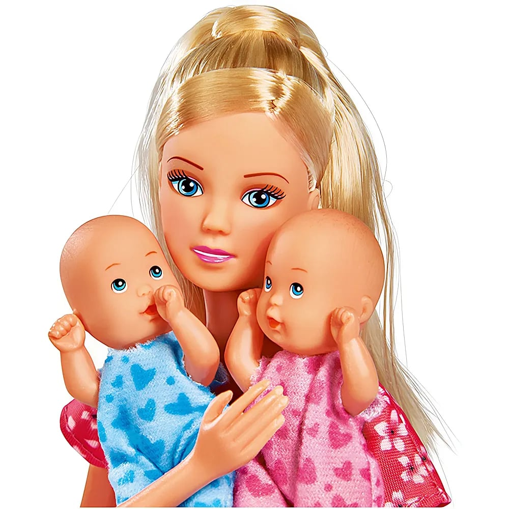 Eine blonde Puppe hält im Arm zwei kleine Babypuppen in blauer und rosa Kleidung.