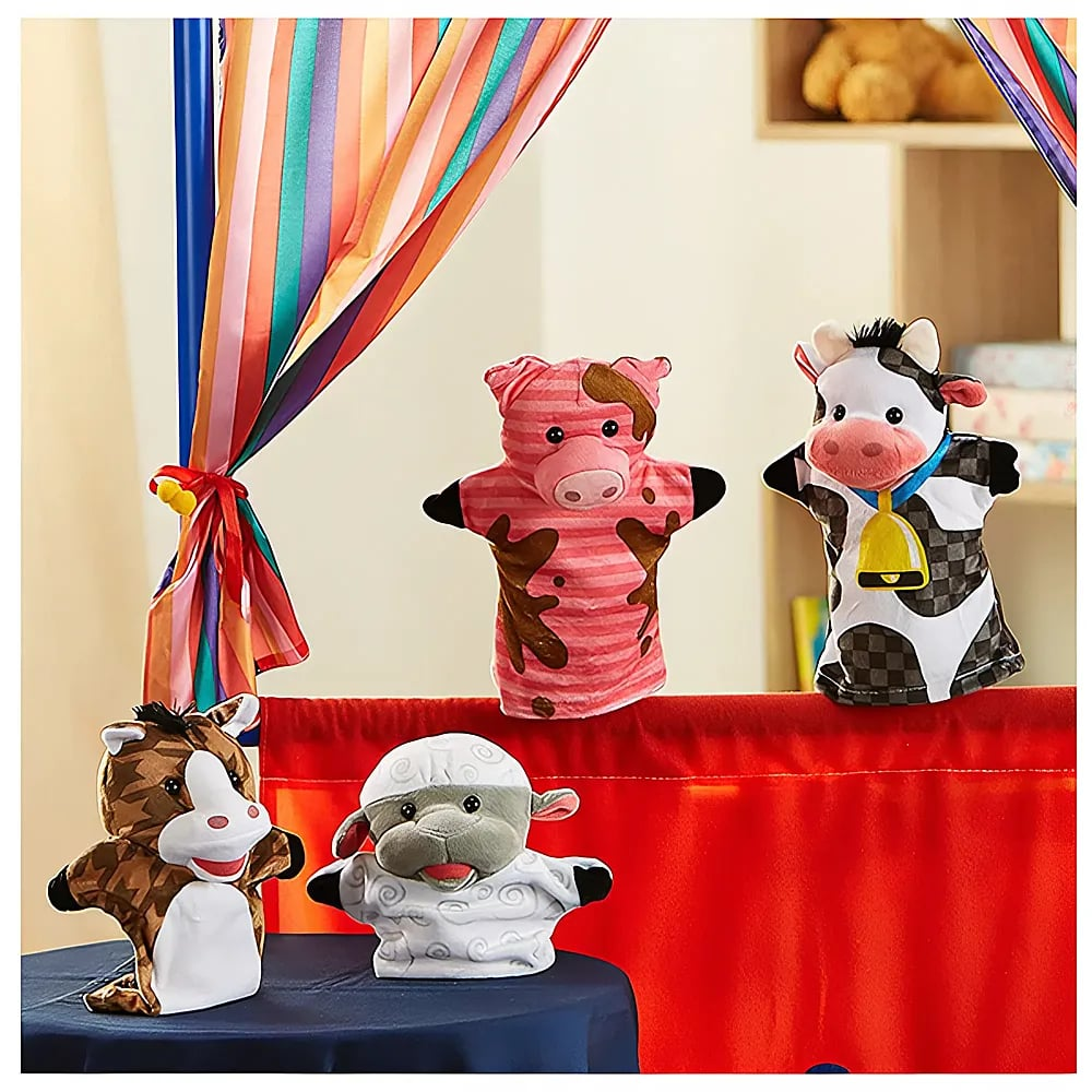 Vier Bauernhoftier-Handpuppen, darunter Pferd, Schaf, Schwein und Kuh, stehen vor einem bunten Vorhang.