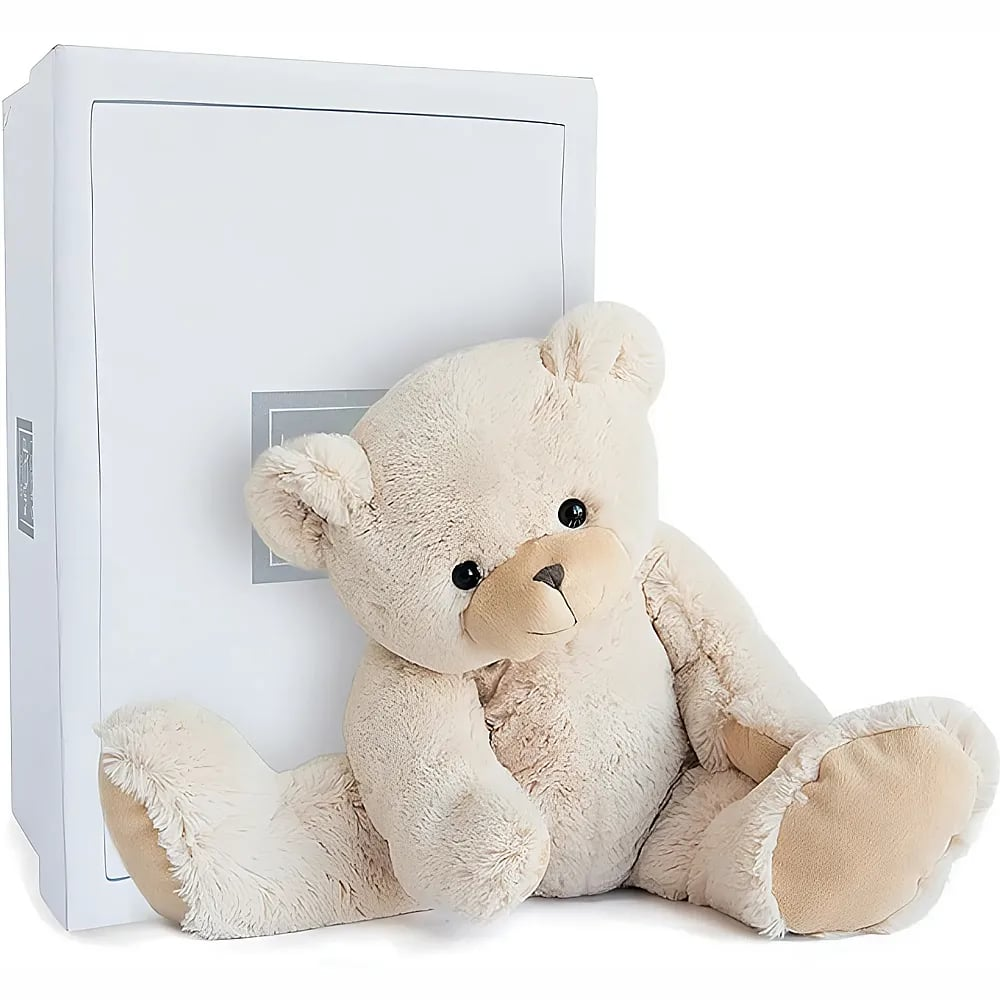 Ein flauschiger, hellbeiger Teddybär sitzt vor einer großen, weißen Geschenkbox auf weißem Hintergrund.
