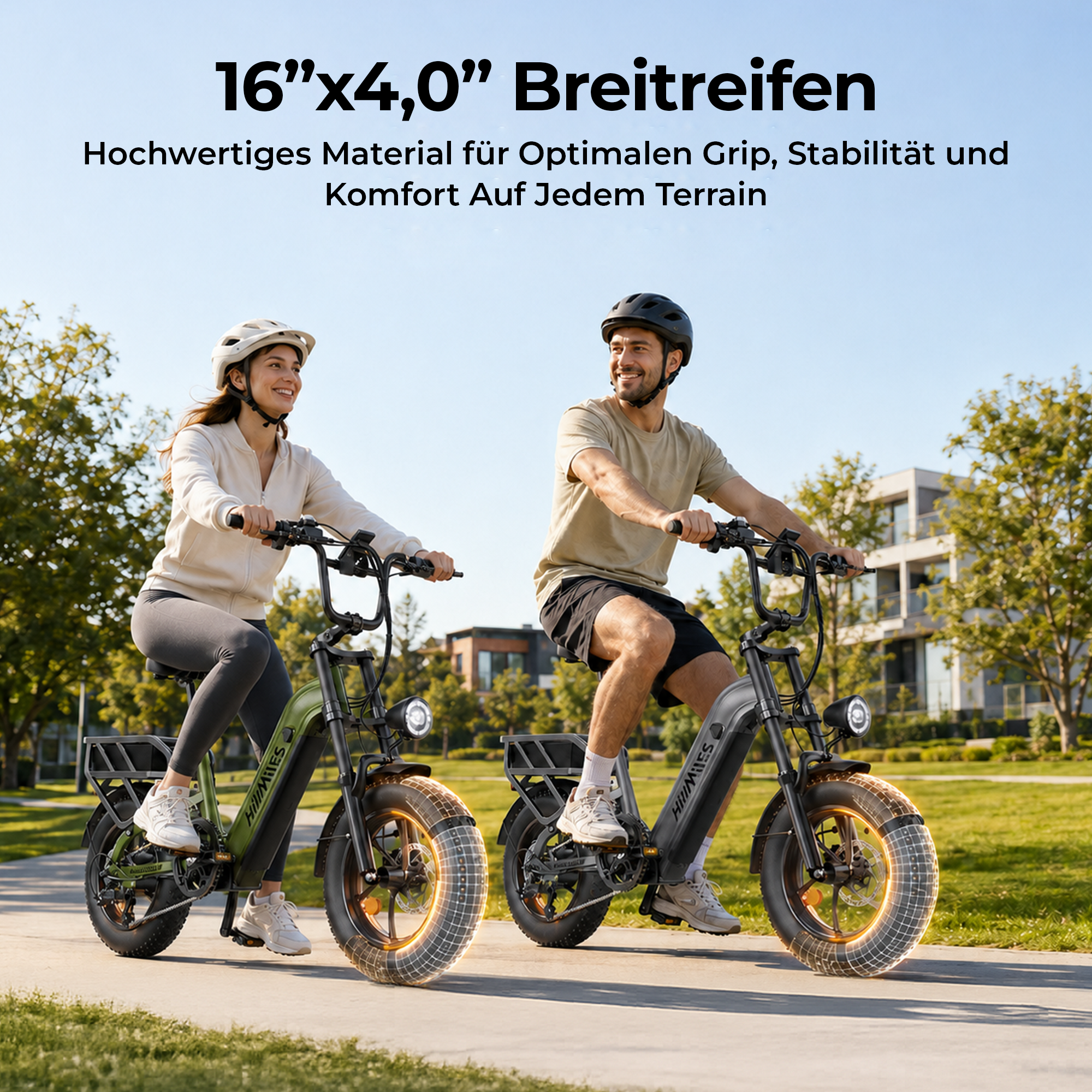 Zwei lächelnde Personen fahren sonntags E-Bikes mit breiten Reifen auf einem gepflasterten Weg im Park.