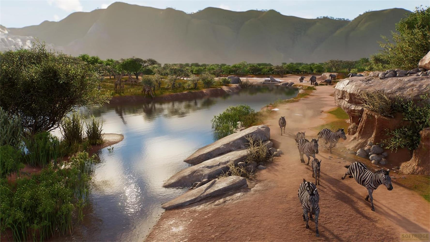 Un troupeau de zèbres court le long d'une rivière, avec des collines vertes en arrière-plan.