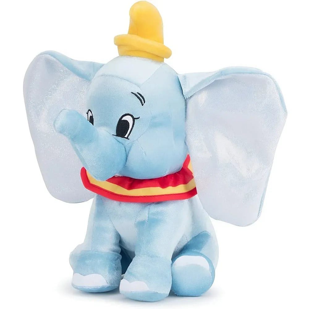 Ein Dumbo-Plüschelefant mit großen Ohren, einem rot-gelben Kragen und einem kleinen gelben Hut vor weißem Hintergrund.