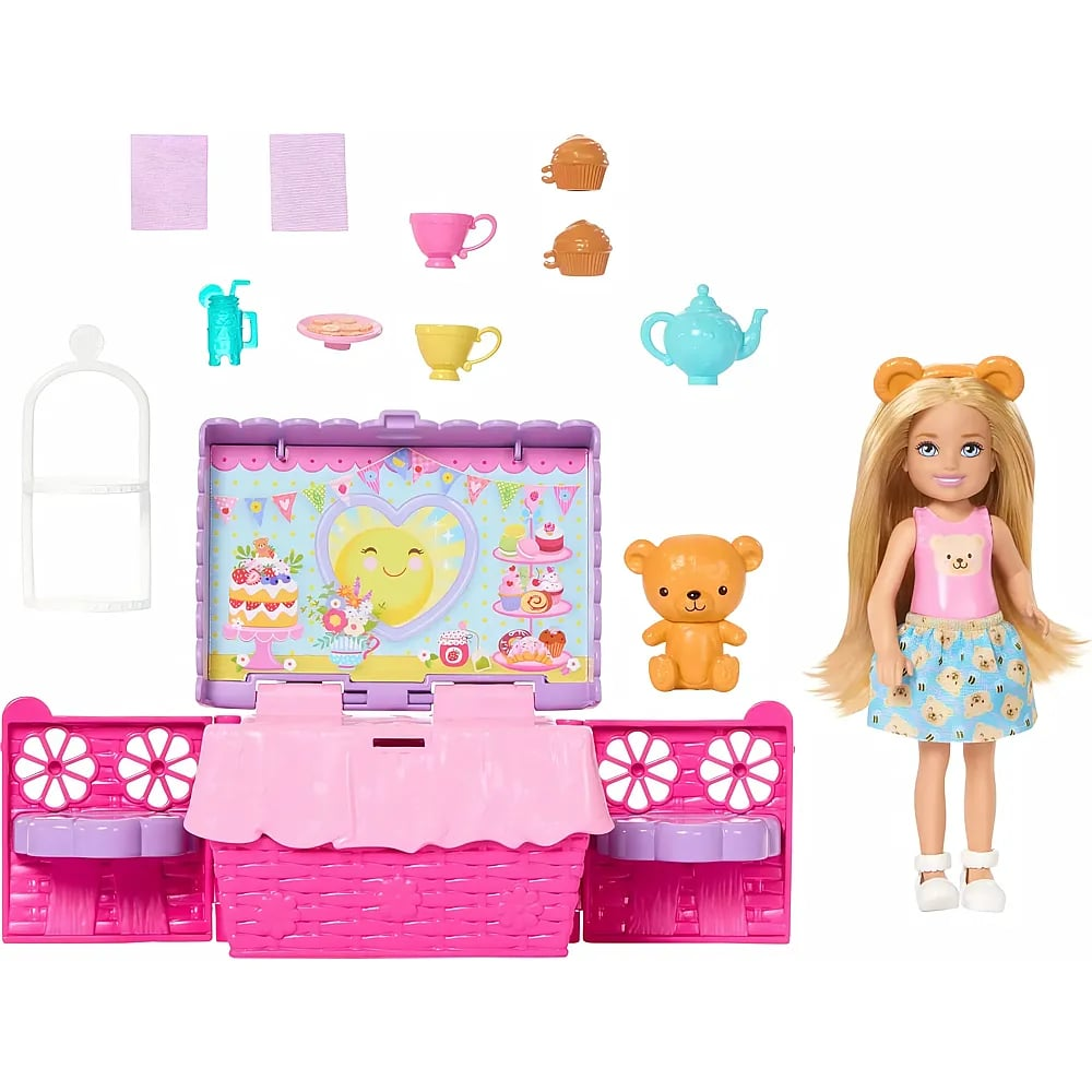 Una muñeca rubia junto a un juego de cesta de picnic rosa, un osito y varios accesorios.