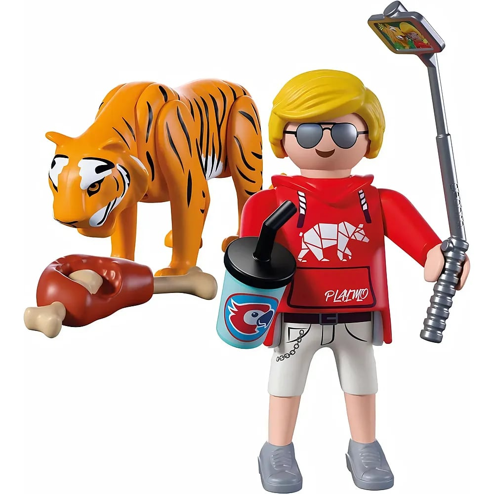 Figura de Playmobil con sudadera roja, bebida y palo selfie, junto a un tigre con un hueso.