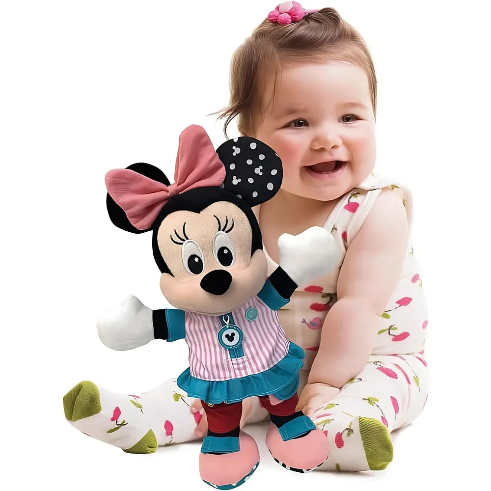 Ein lächelndes Baby hält ein Plüsch-Minnie-Maus-Spielzeug vor weißem Hintergrund.