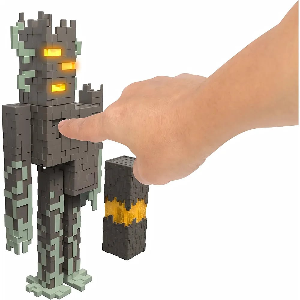 Eine Hand berührt eine graue Blockfigur mit leuchtenden gelben Augen auf weißem Hintergrund.