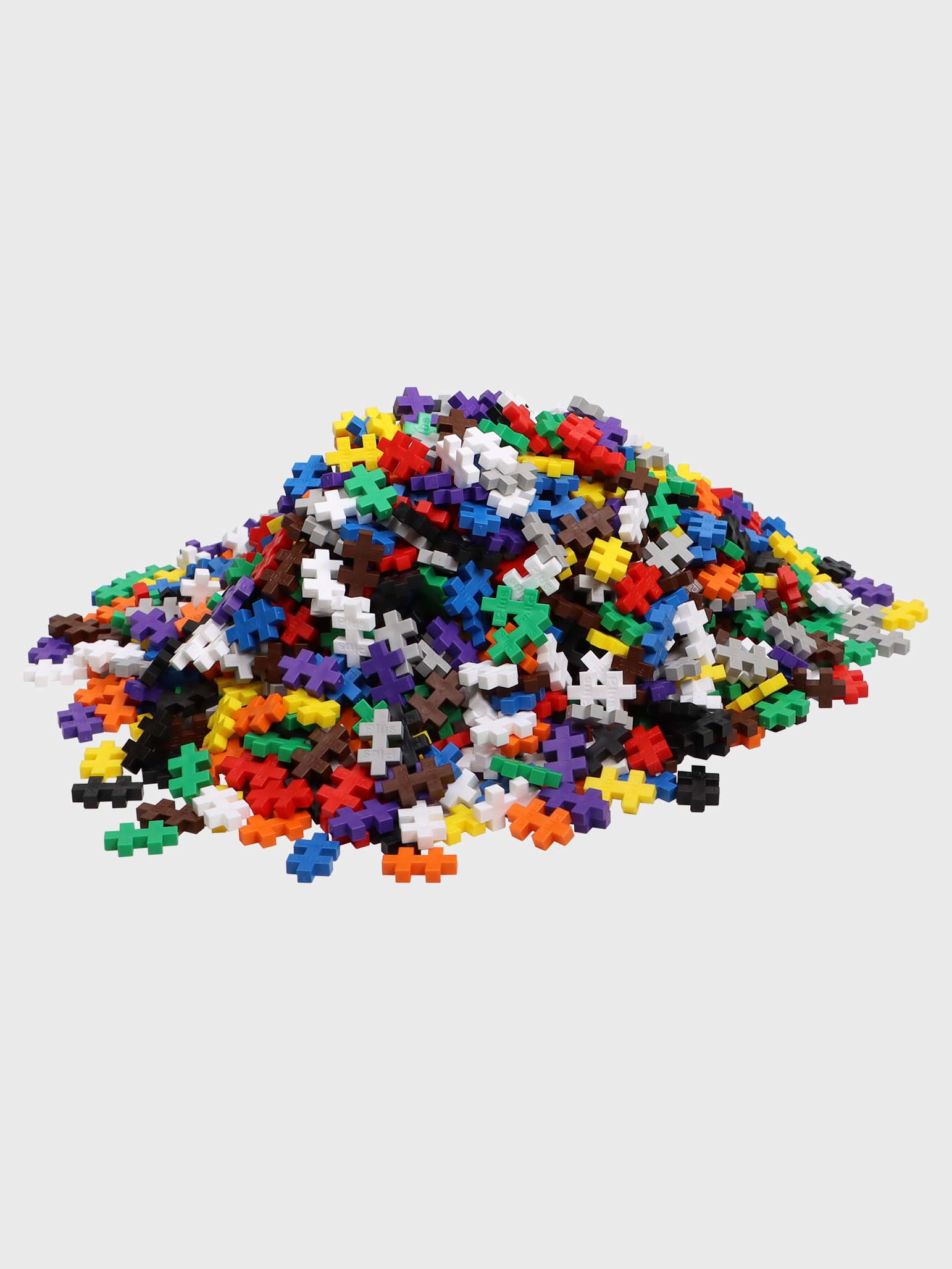 Un grande mucchio di colorati pezzi di giocattoli Plus-Plus su sfondo chiaro.