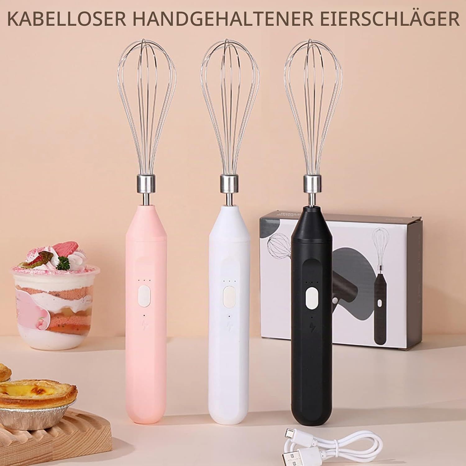Drei kabellose Handrührgeräte in Rosa, Weiß und Schwarz stehen nebeneinander vor einer Produktverpackung.