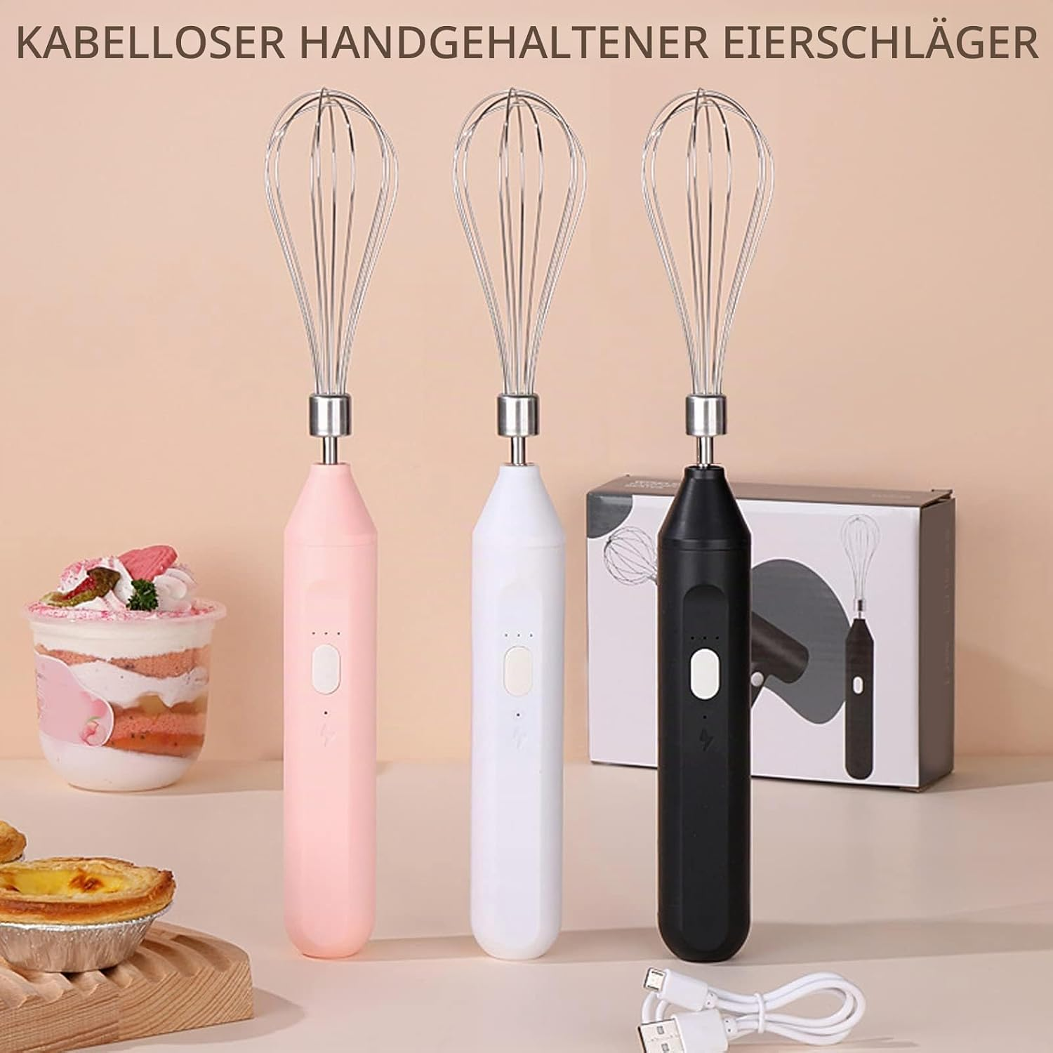 Drei kabellose Handrührgeräte in Rosa, Weiß und Schwarz stehen nebeneinander mit einem Produktkarton und Gebäck.