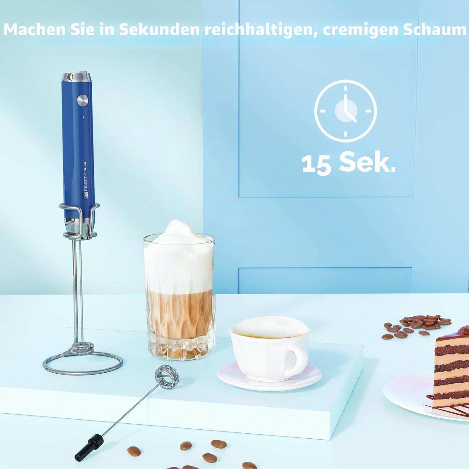 Ein blauer Milchaufschäumer, ein Glas Latte Macchiato und eine Kaffeetasse stehen auf einem Tisch.