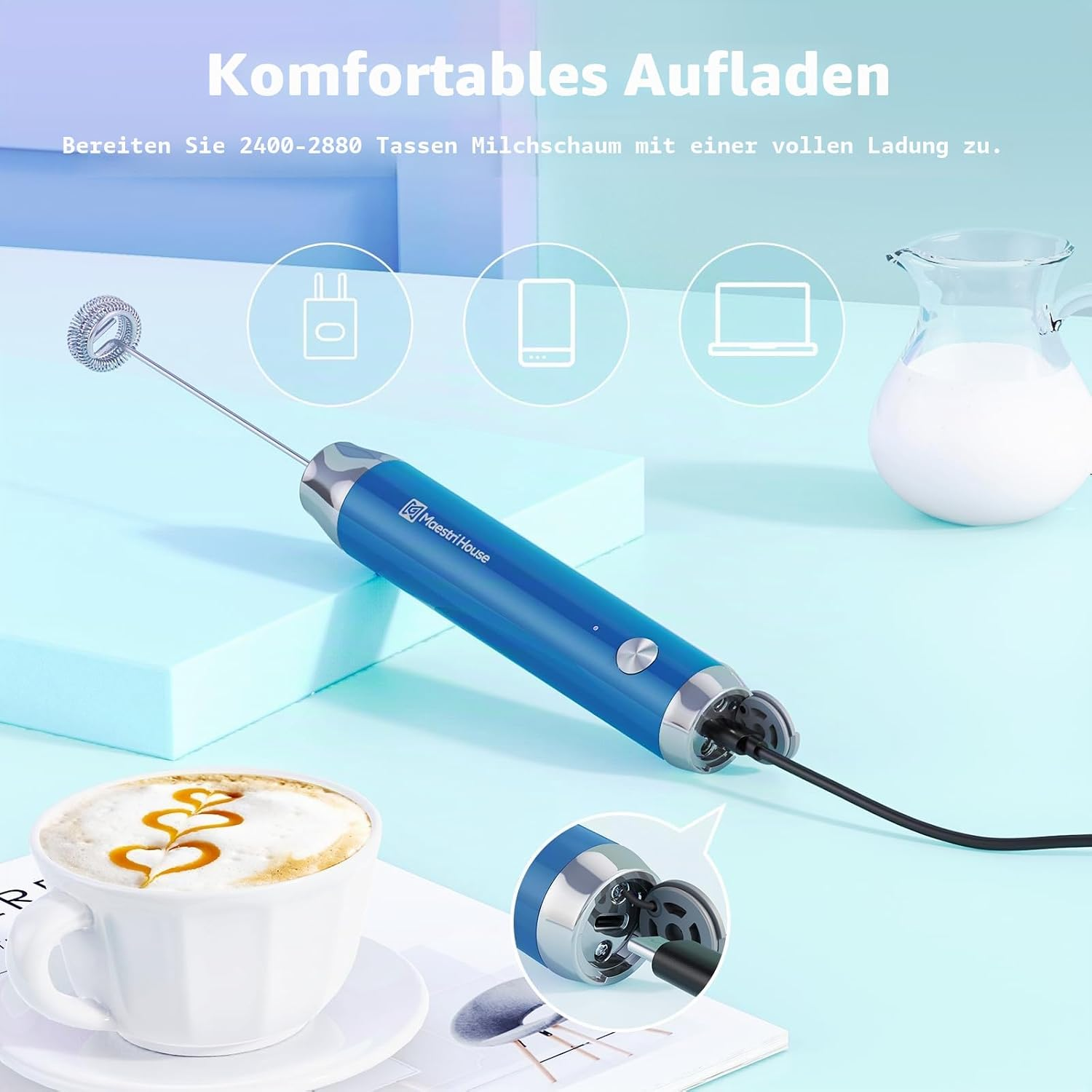 Ein blauer Milchaufschäumer wird mit einem Kabel auf einer hellblauen Oberfläche neben einer Tasse Kaffee geladen.