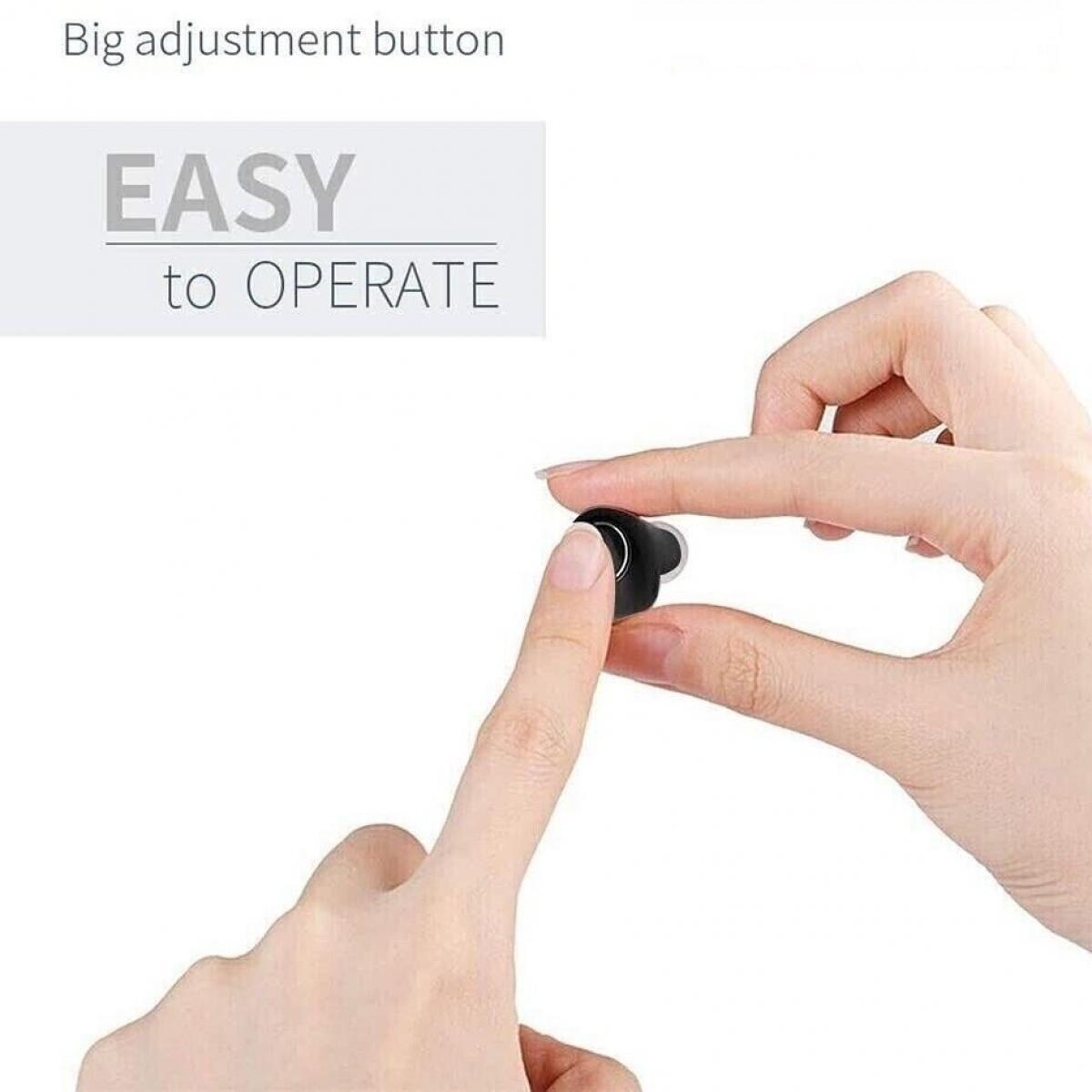 Ein Finger drückt den großen Einstellknopf an einem kleinen schwarzen Hörgerät.