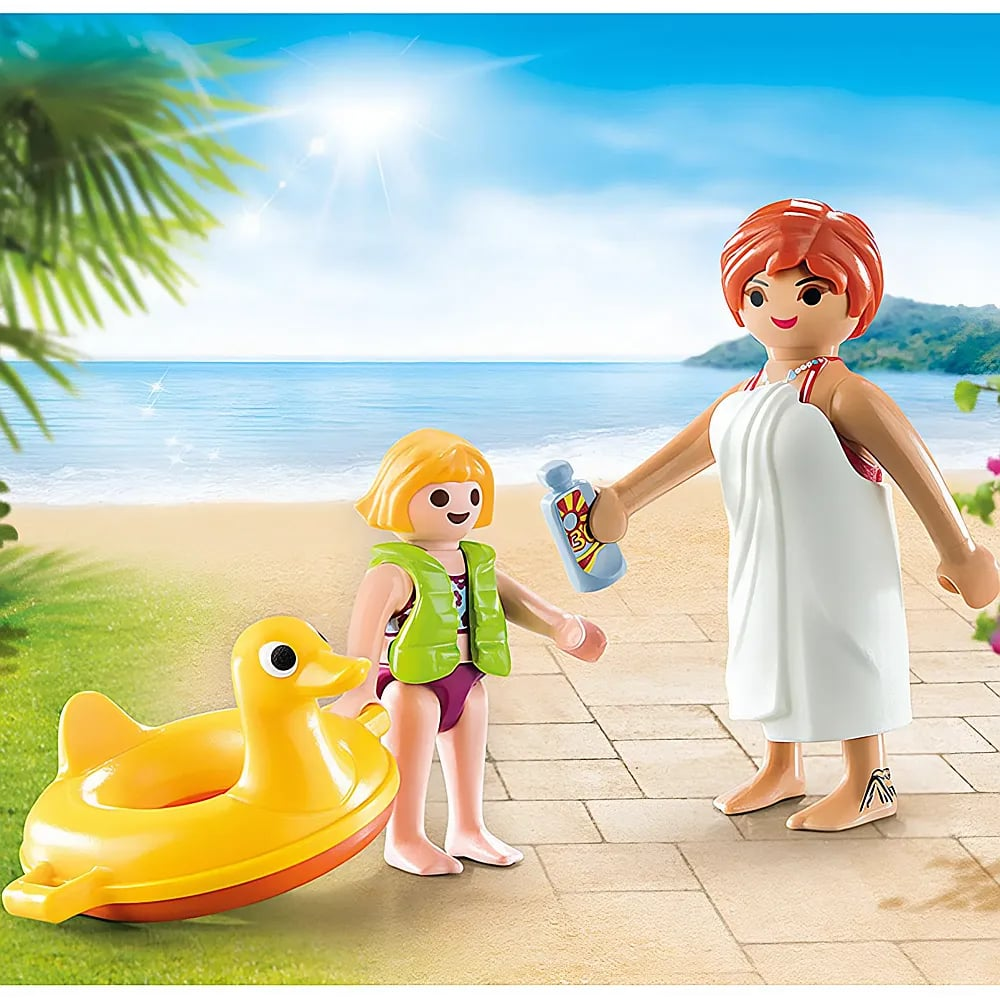 Personaggi Playmobil in spiaggia: una donna con asciugamano tiene la crema solare e un bambino indossa un giubbotto di salvataggio.