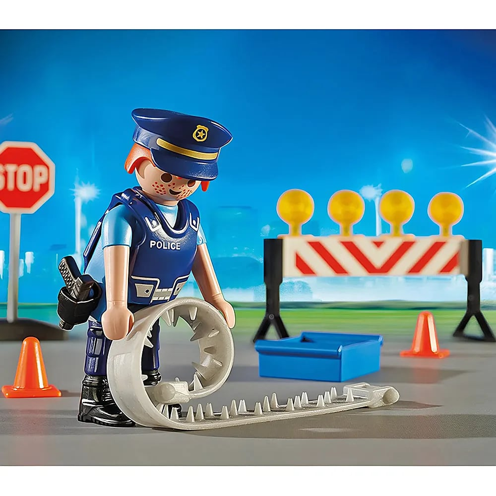 Ein Playmobil-Polizist rollt eine Nagelmatte vor einer Straßensperre aus.