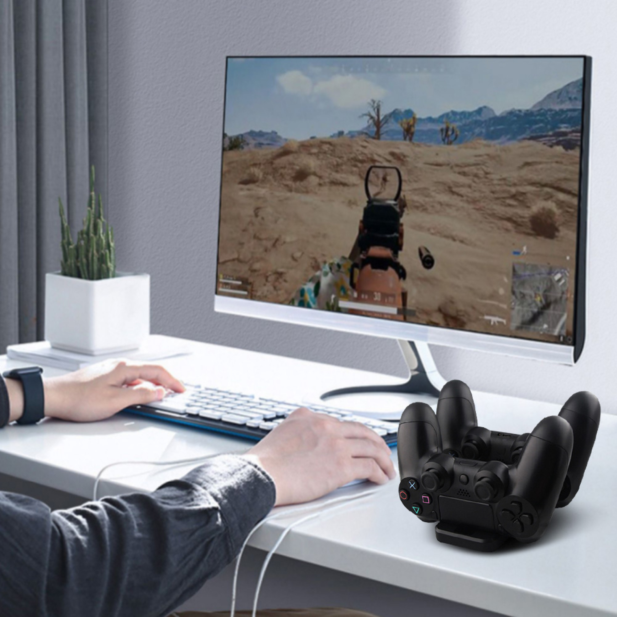 Eine Person spielt ein Wüsten-Shooter-Spiel am Computer, während ein schwarzer Controller-Ständer auf dem Tisch steht.