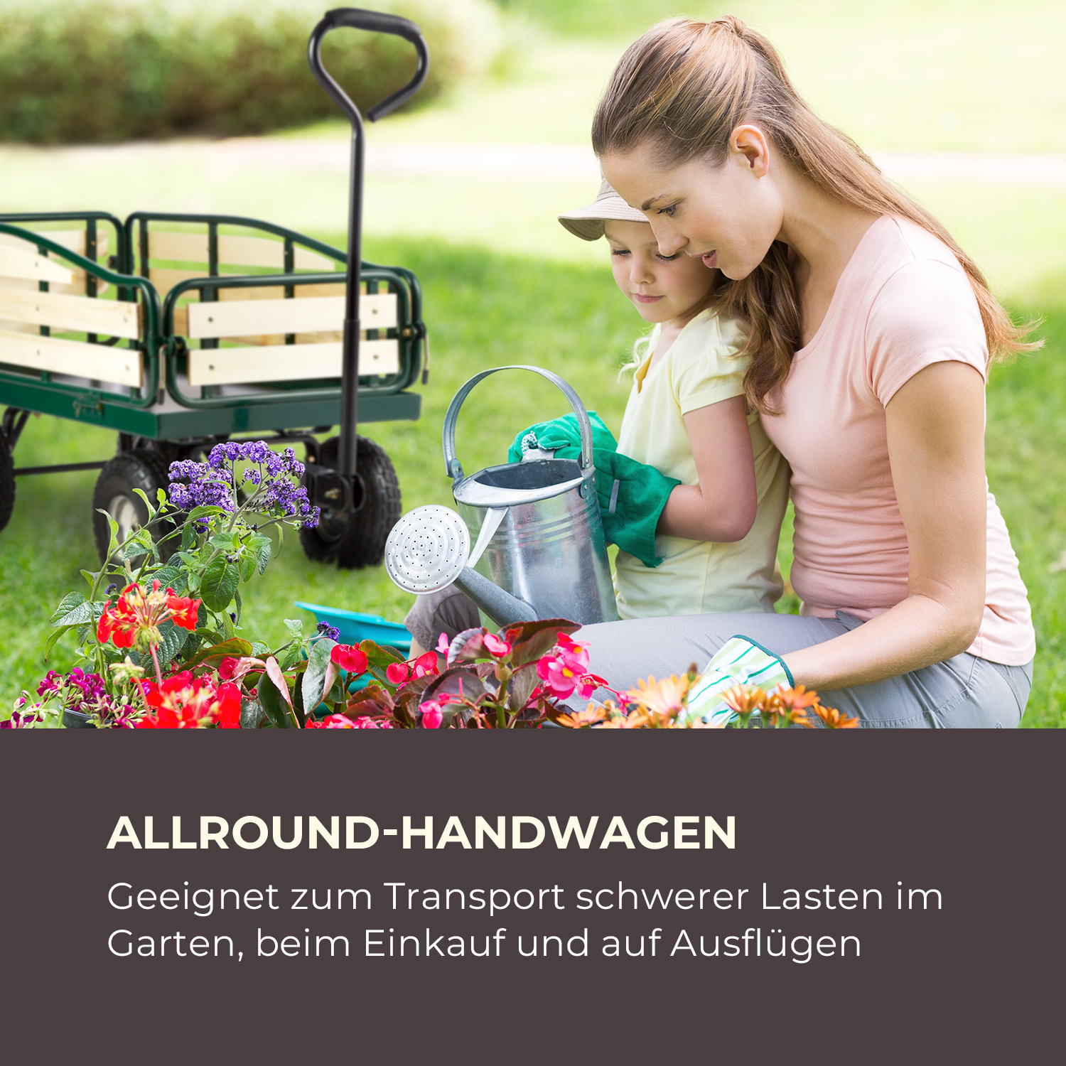 Eine Frau und ein Kind gießen Blumen neben einem Handwagen auf einer Wiese.