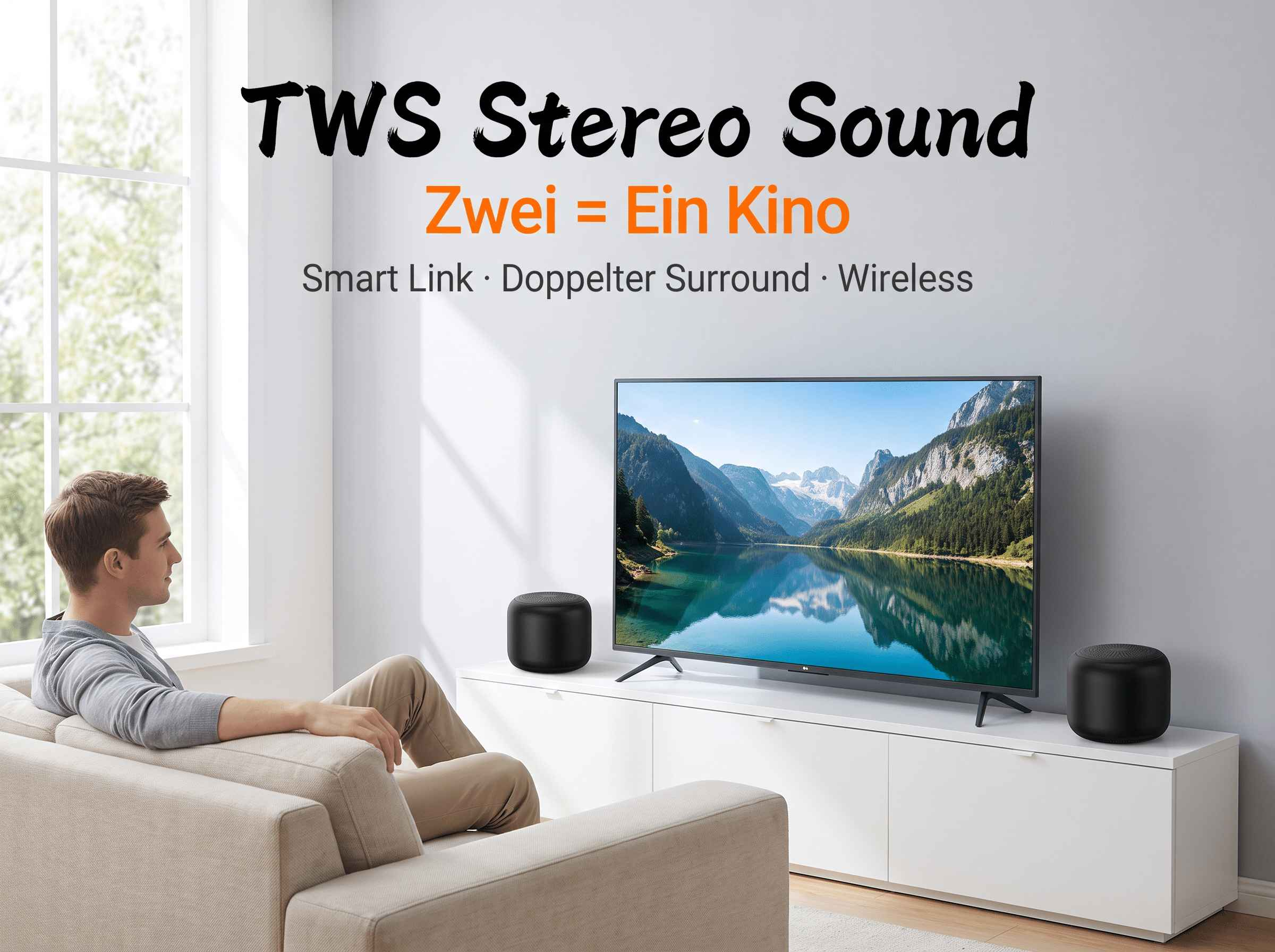 Ein Mann sitzt vor einem Fernseher und zwei schwarzen Lautsprechern auf einem Schrank in einem hellen Wohnzimmer.