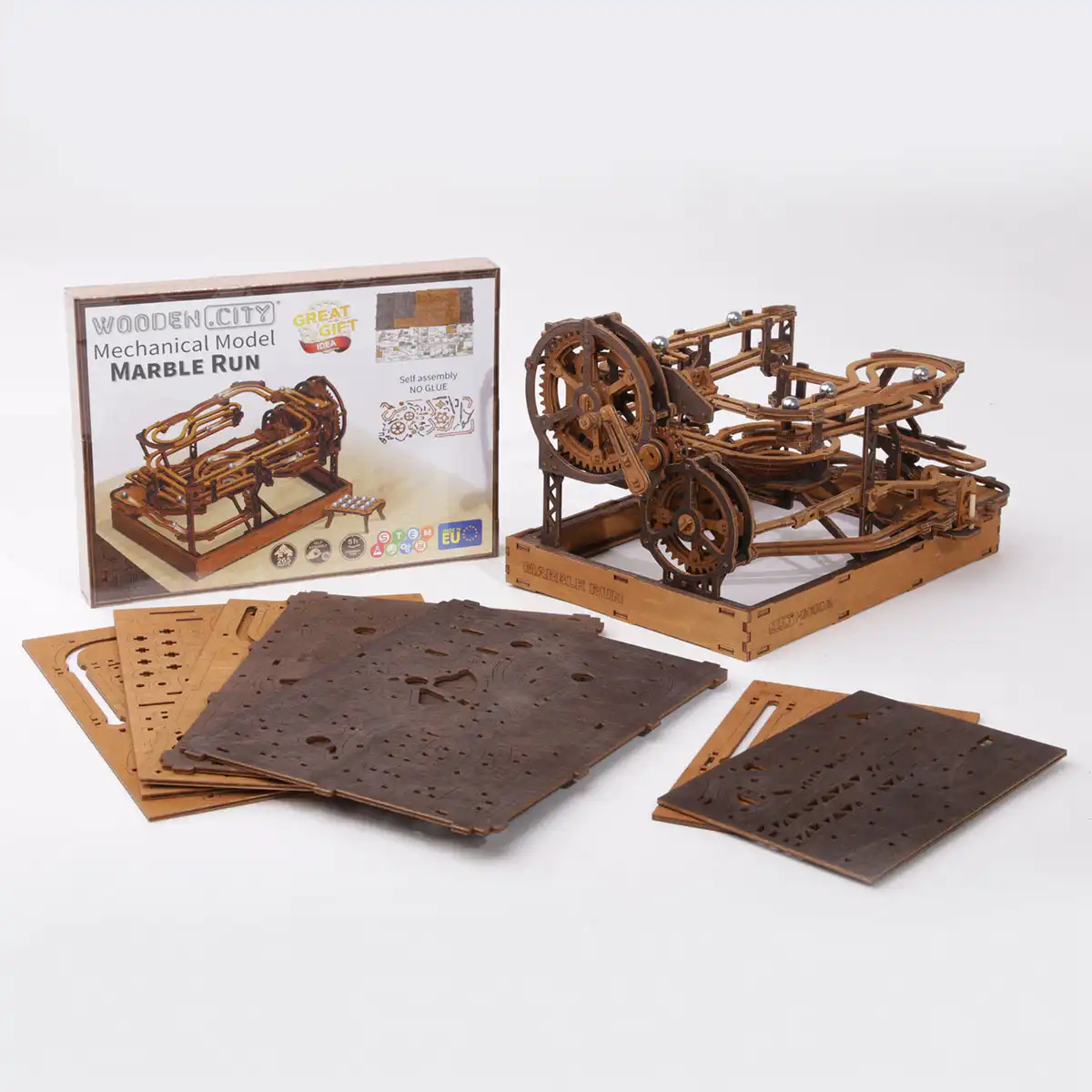 Un modèle de circuit à billes en bois avec sa boîte et des plaques de bois découpées au laser.