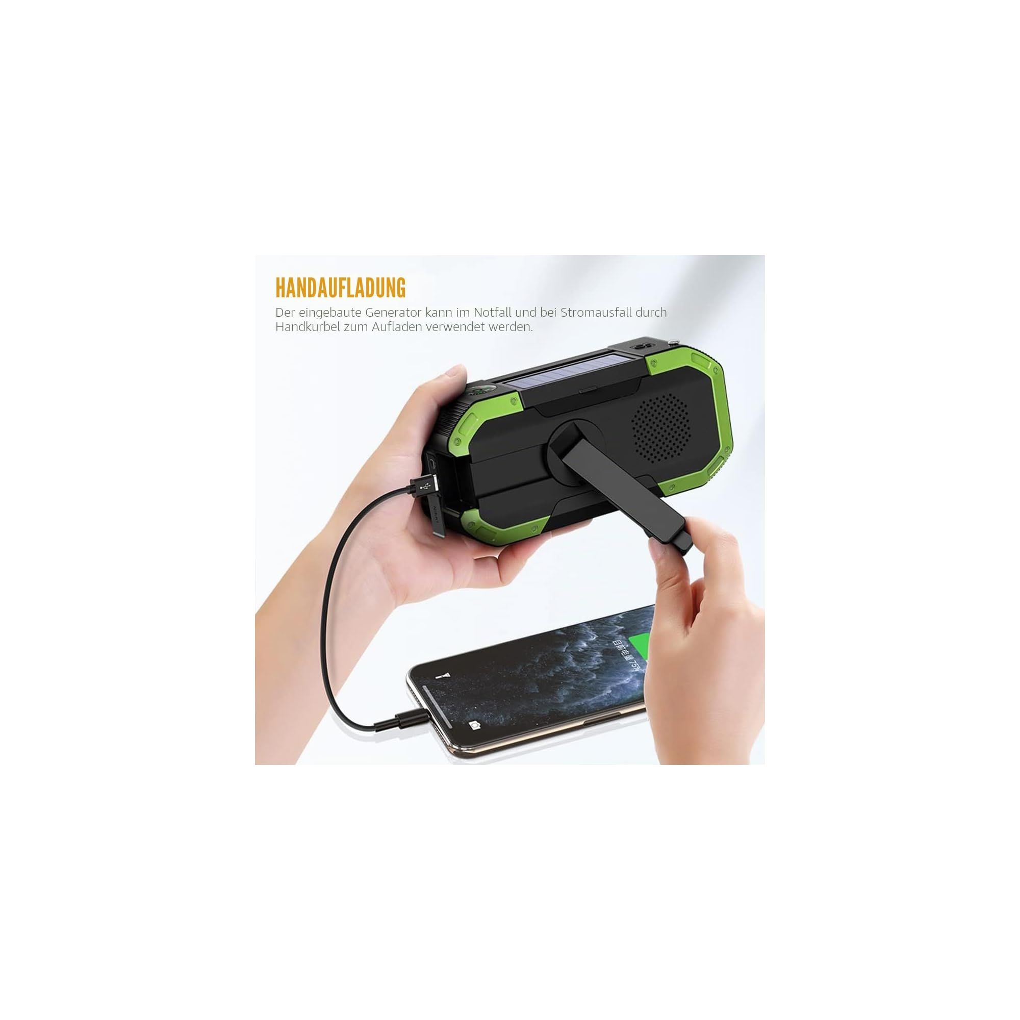 Eine Hand bedient die Kurbel einer grünen Notfall-Powerbank, die ein Smartphone auflädt.