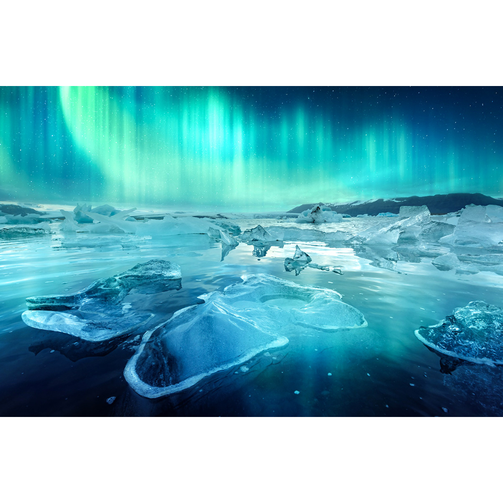 Grüne Nordlichter leuchten über einer ruhigen Eislandschaft mit schwimmenden Eisschollen im Wasser.