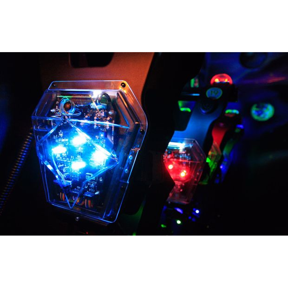 Sechseckiges, blaues LED-Bauteil im Gehäuse mit rotem Licht im dunklen Hintergrund.