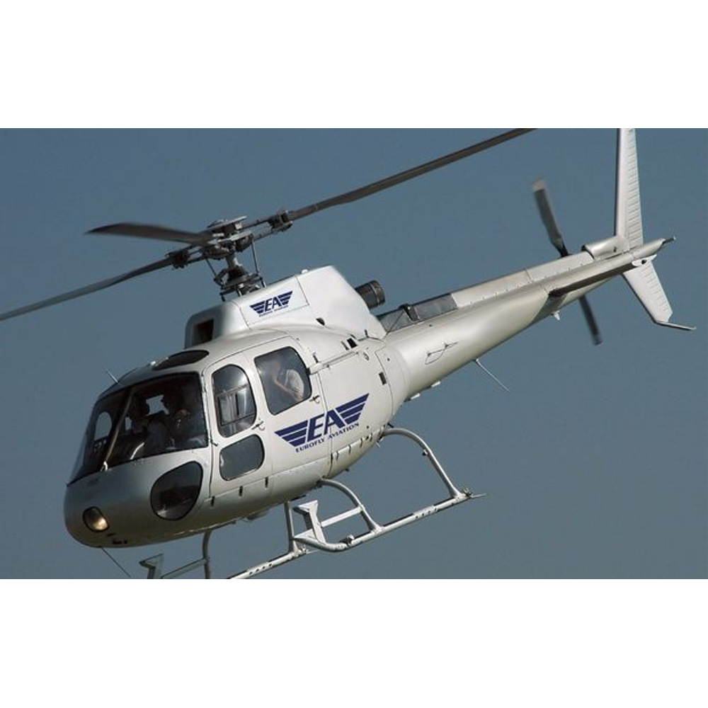 Ein weißer Eurofly Aviation Hubschrauber fliegt am klaren blauen Himmel.