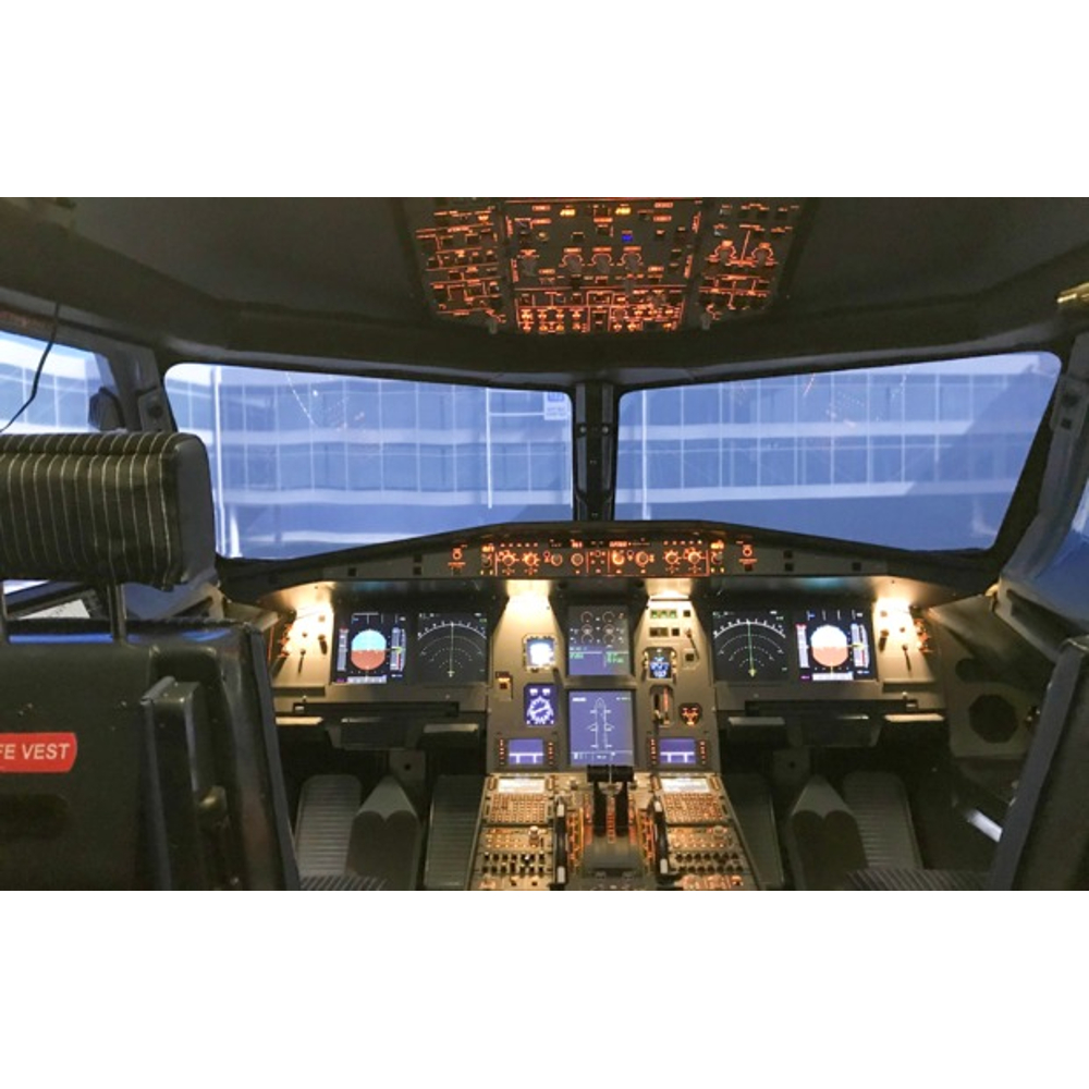 Blick aus dem Cockpit eines Flugzeugs mit beleuchteten Instrumententafeln und Frontscheiben mit Außensicht.