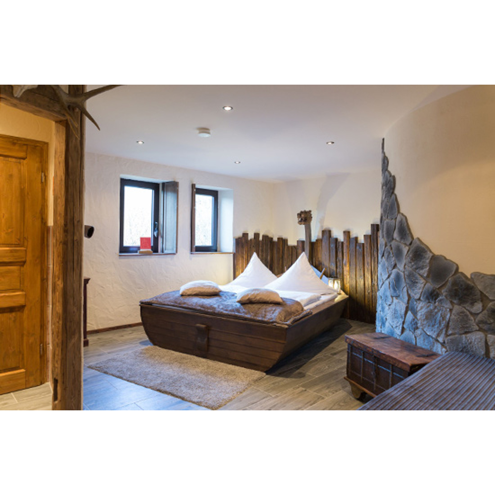 Gemütliches Schlafzimmer mit Holzbett, das wie ein Boot geformt ist, Steinwand und Holzakzenten.