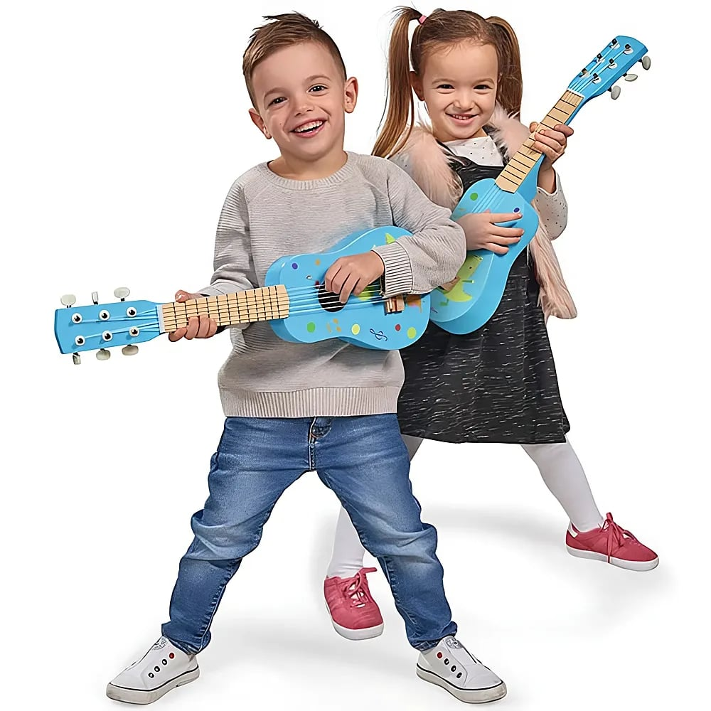 Ein Junge und ein Mädchen in lässiger Kleidung spielen glücklich auf bunten blauen Spielzeuggitarren vor weißem Grund.
