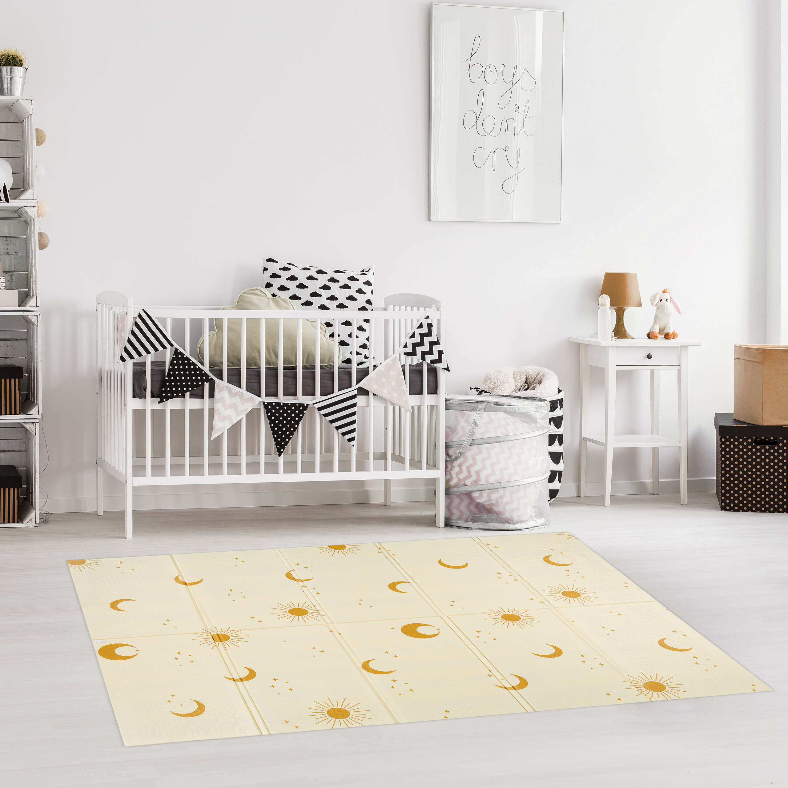 Ein weißes Babybett mit Kissen und Girlande in einem hellen Kinderzimmer mit gelbem Teppich.