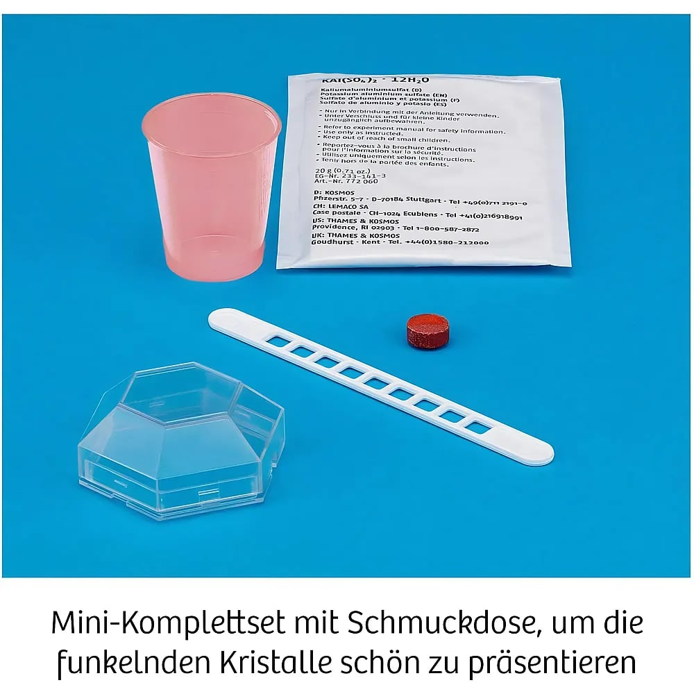 Ein Set mit rosa Becher, Chemikalienbeutel, weißem Spatel, roter Tablette und transparenter Box auf blauem Grund.