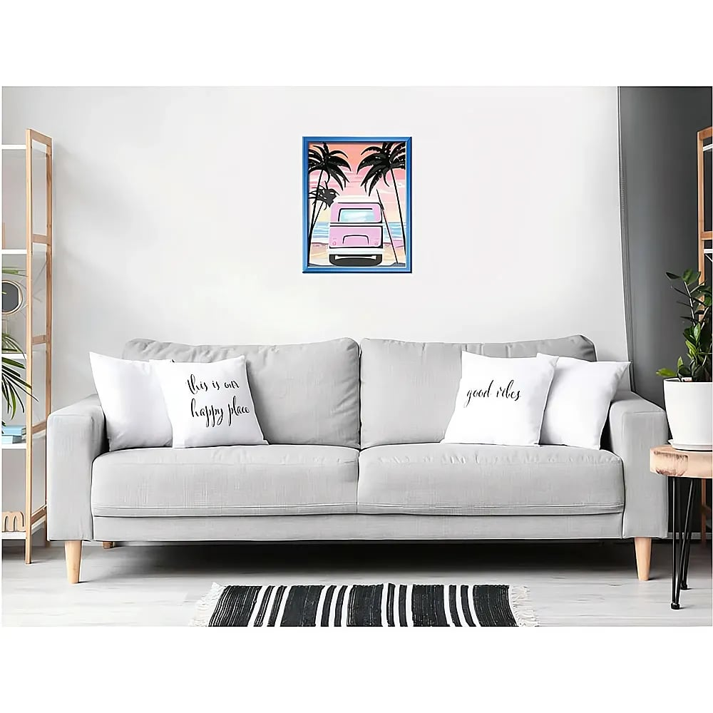 Ein graues Sofa mit vier Kissen und einem gerahmten Strandgemälde darüber, flankiert von Regalen und einer Topfpflanze.