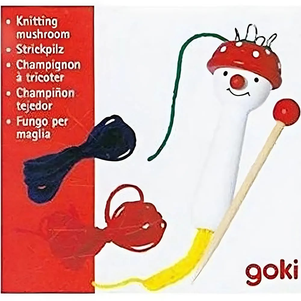 Ein Strickpilz mit bunten Fäden und einem passenden Holzstab vor rotem und weißem Hintergrund.