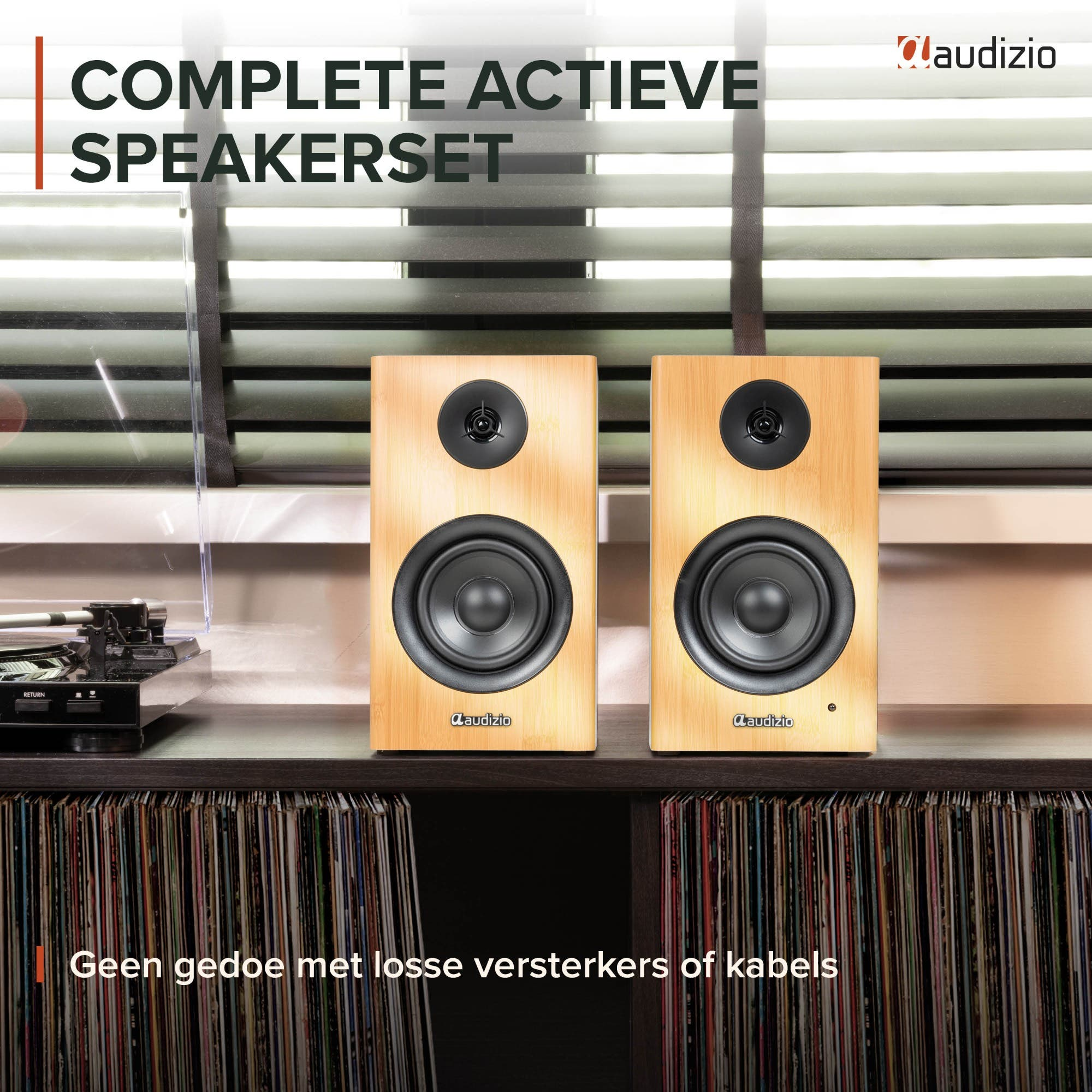 Dos altavoces de madera clara sobre un estante con discos y un tocadiscos.