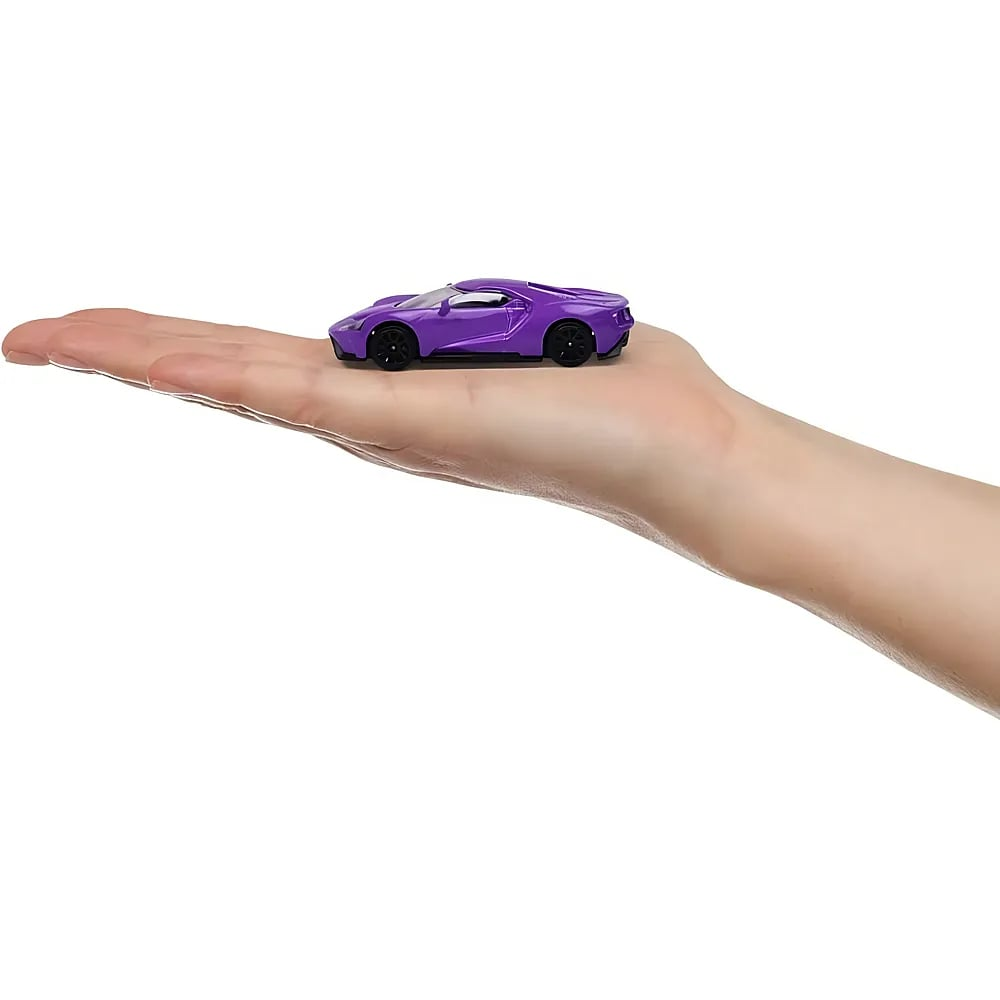 Une petite voiture de sport violette repose sur la paume ouverte d'une personne.