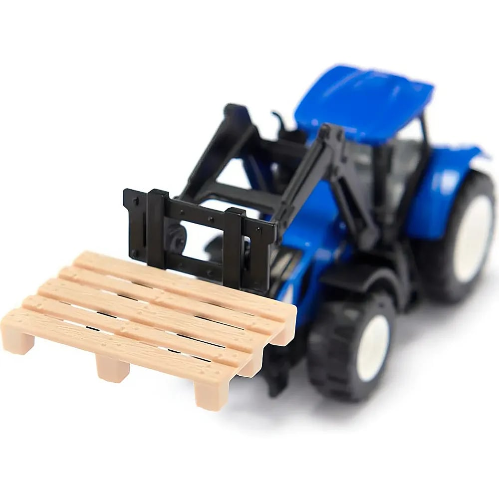 Ein blaues Traktor-Spielzeug mit schwarzem Lader hält eine kleine Holzpalette vor einem weißen Hintergrund.