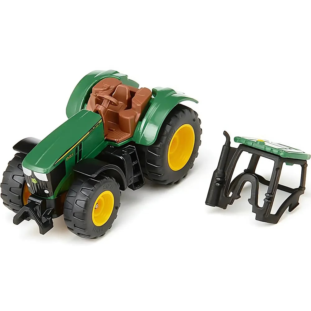 Ein grüner Spielzeugtraktor mit braunem Sitz und gelben Rädern, daneben die abnehmbare schwarze Kabine.