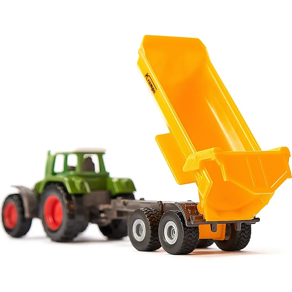 Un trattore giocattolo verde traina un grande rimorchio ribaltabile giallo sollevato.