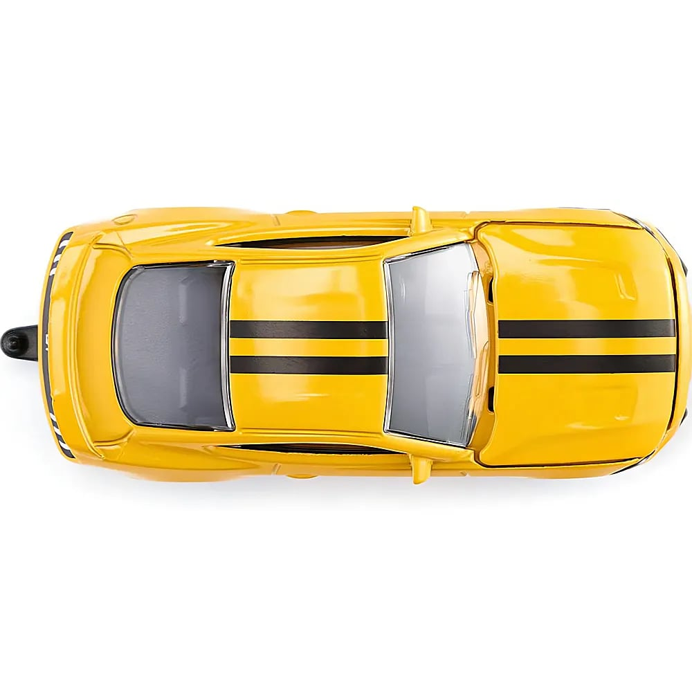 Top-Down-Ansicht eines gelben Spielzeugautos mit zwei schwarzen Streifen auf einer hellen Unterlage.