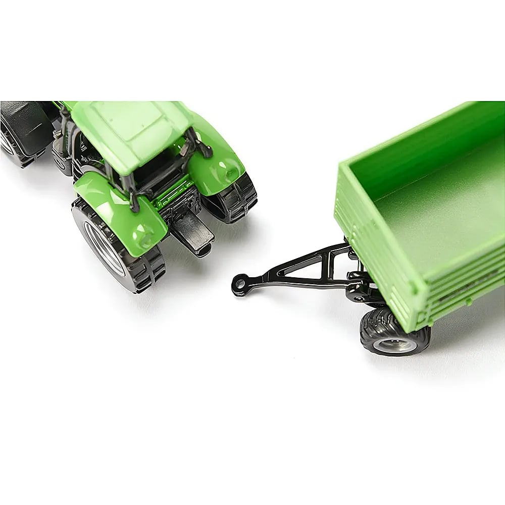 Un trattore giocattolo verde con rimorchio su sfondo bianco.