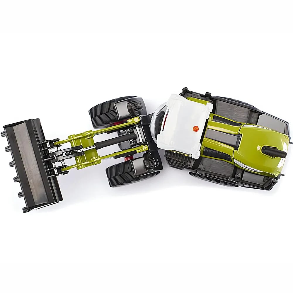 Draufsicht auf einen grünen und weißen Spielzeugtraktor mit Frontlader auf weißem Grund.