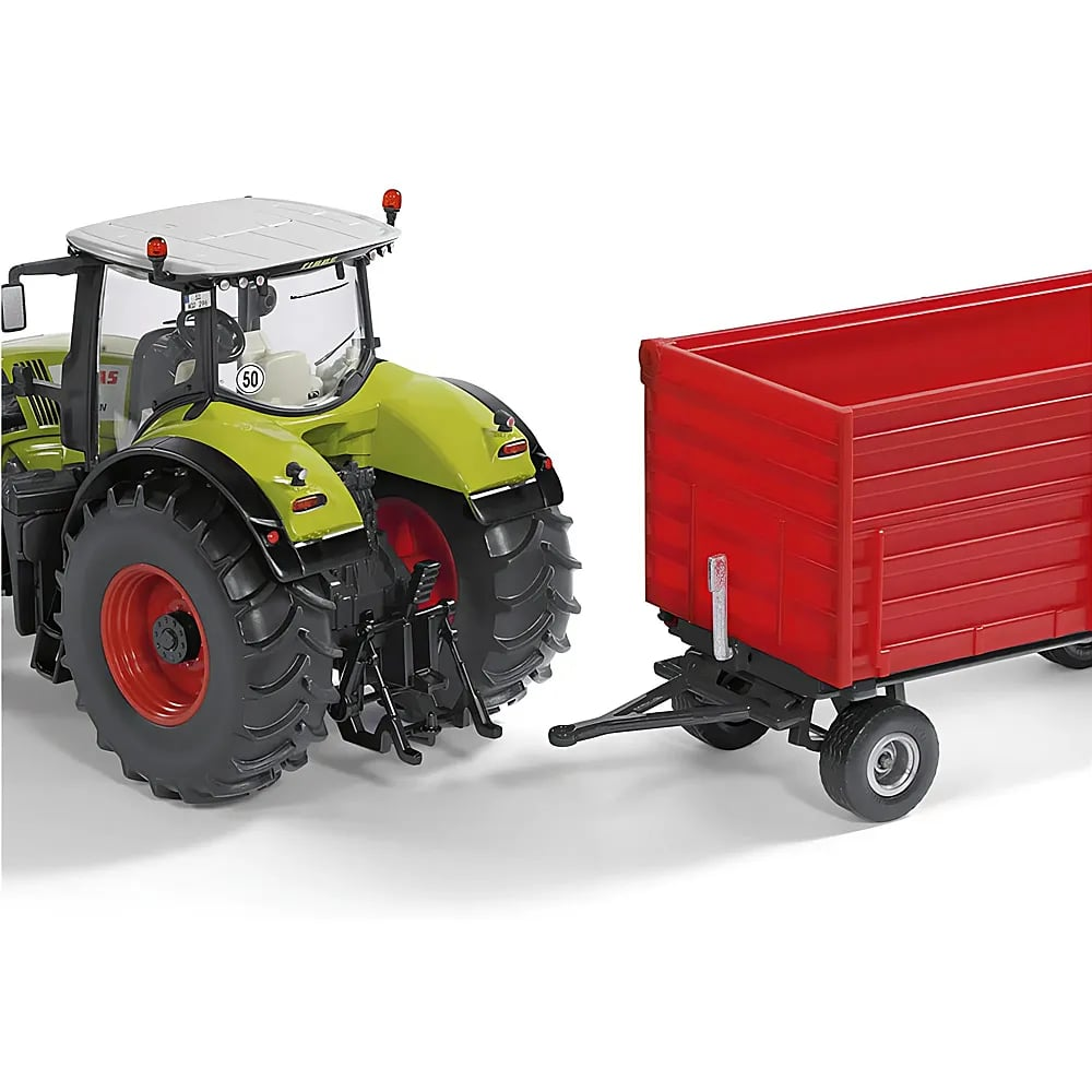 Ein grüner Spielzeugtraktor mit grauem Dach ist geparkt und an einen roten Anhänger gekoppelt auf weißem Grund.