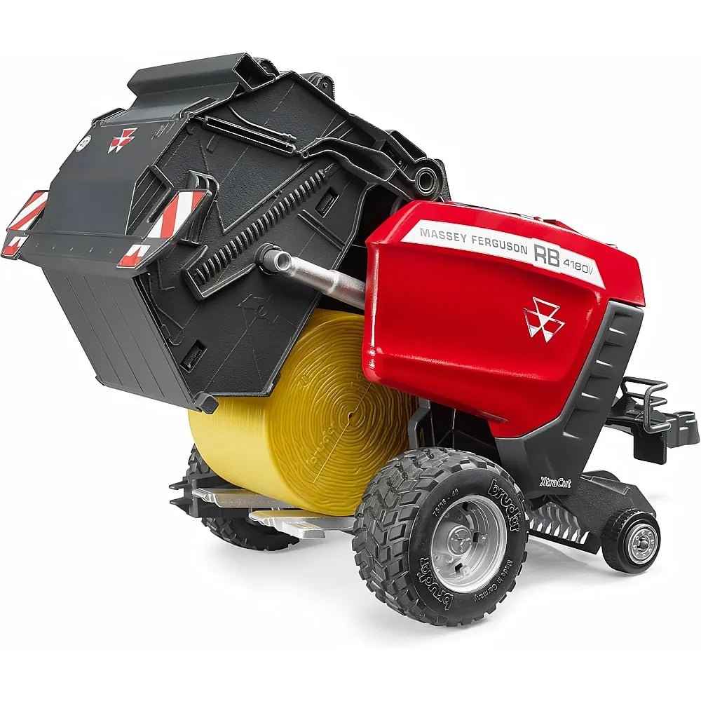 Ein rotes und schwarzes Massey Ferguson Spielzeug-Heuballenpresse Modell auf weißem Hintergrund mit einem gelben Ballen.