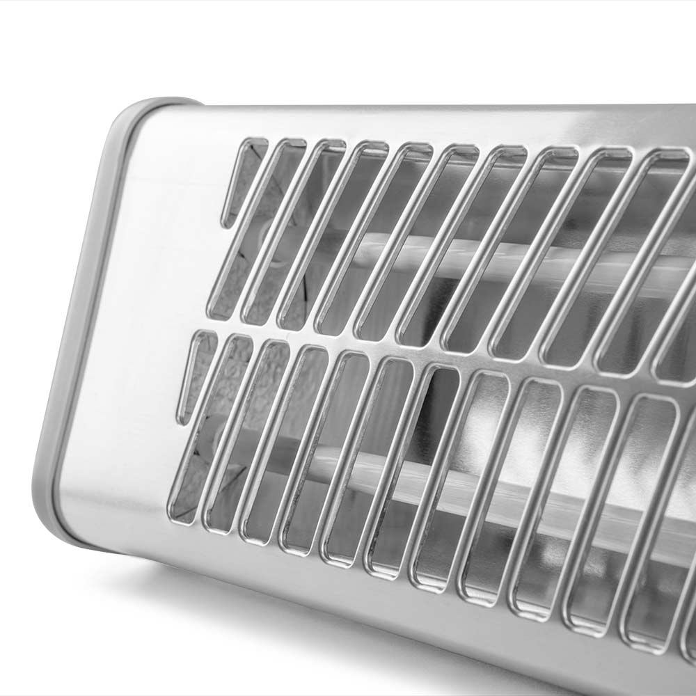Primer plano de un calefactor radiante de metal plateado con ranuras de ventilación paralelas.