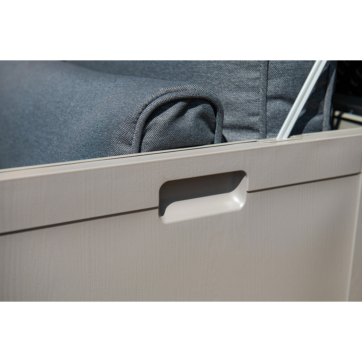 Close-up of a beige storage box with an integrated handle and a grey fabric cushion.