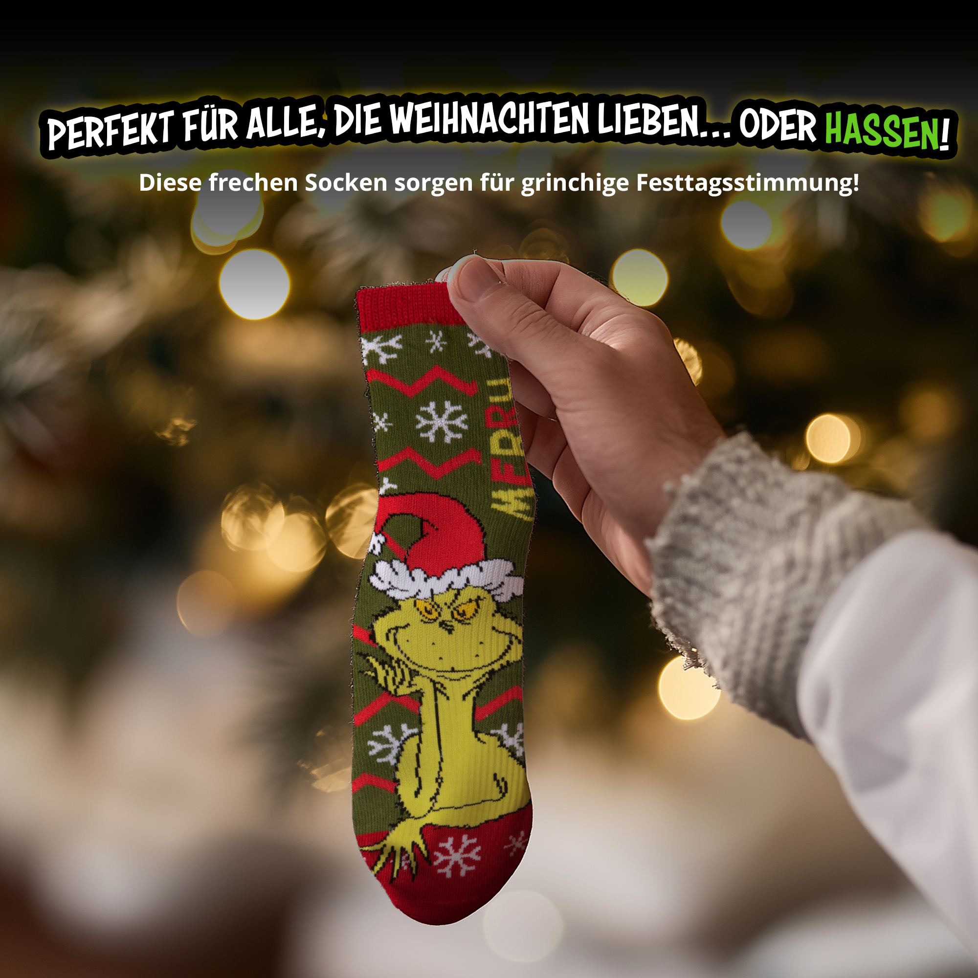 Hand hält grüne Weihnachtssocke mit Grinch-Motiv vor verschwommenem Lichterbaum.
