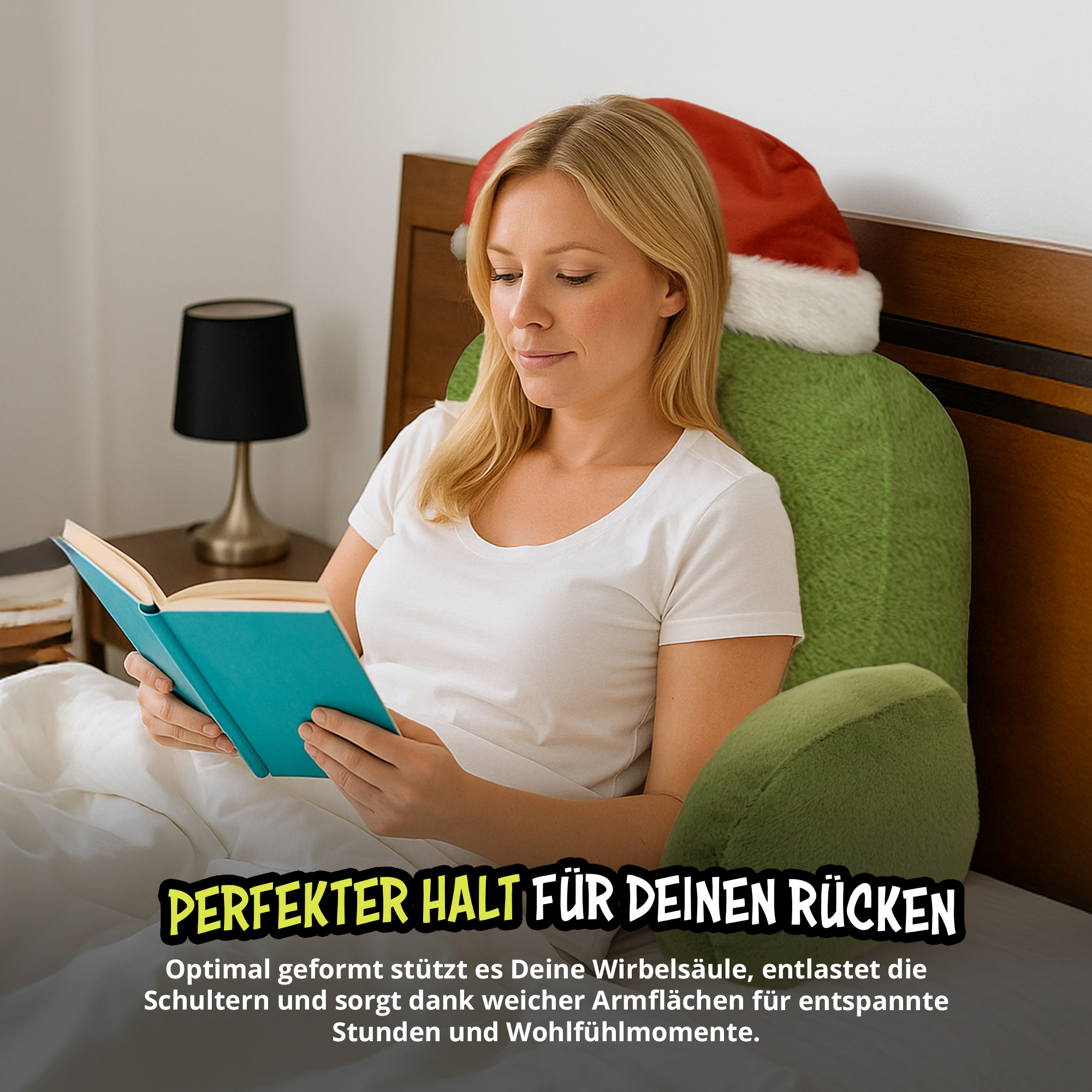 Eine blonde Frau im Bett liest ein Buch und lehnt an einem grünen Stützkissen mit Weihnachtsmütze.