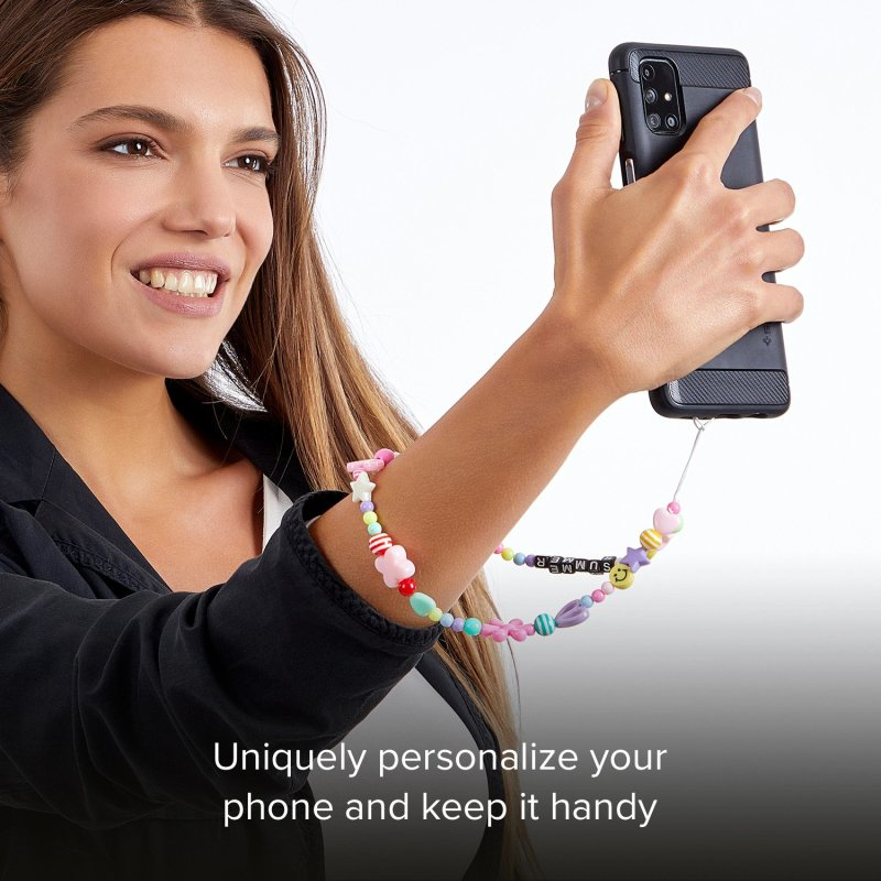 Eine lächelnde Frau hält ein Handy mit einer bunten Perlenhandschlaufe.