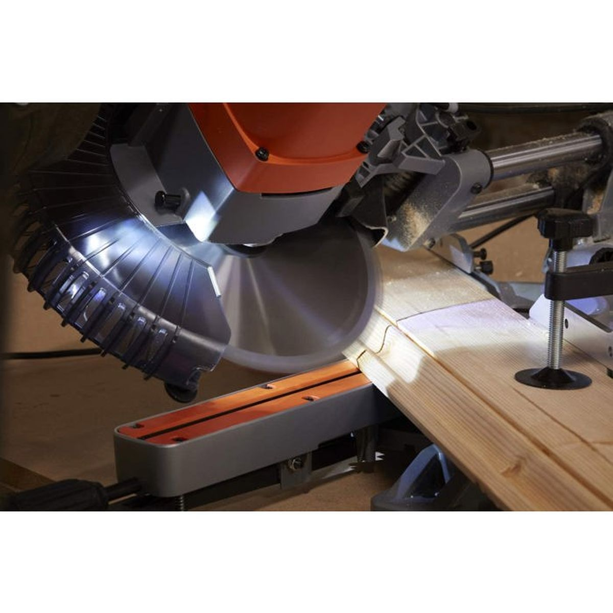 Eine Kreissäge schneidet Holz, beleuchtet durch eine Arbeitslampe.
