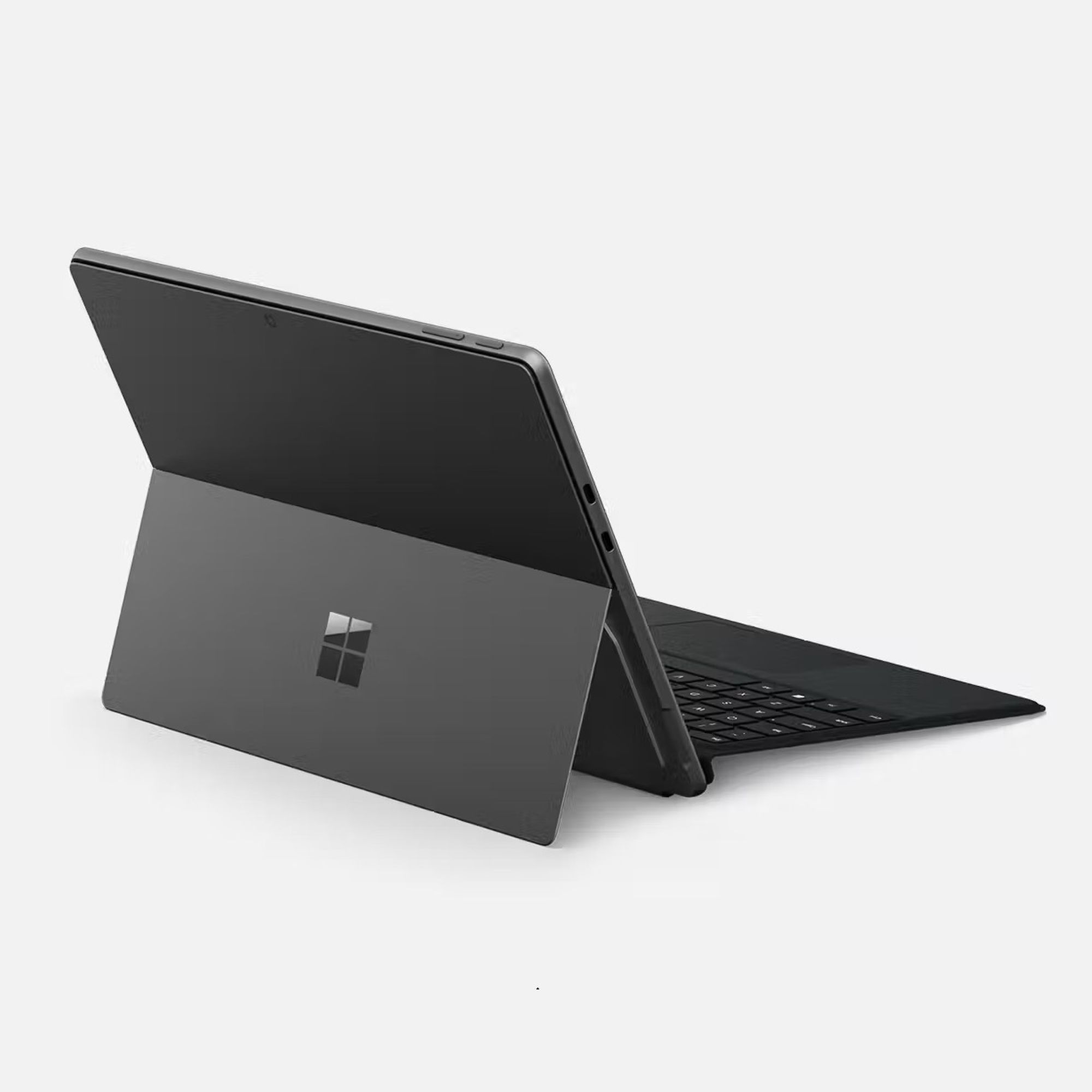Un tablet grigio Microsoft Surface con tastiera collegata poggia su una superficie chiara.
